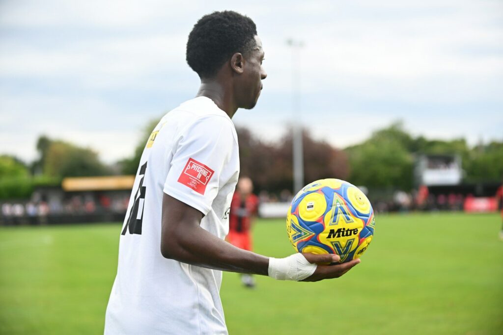 A man holding a soccer ball on a field