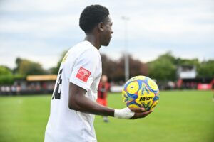 A man holding a soccer ball on a field